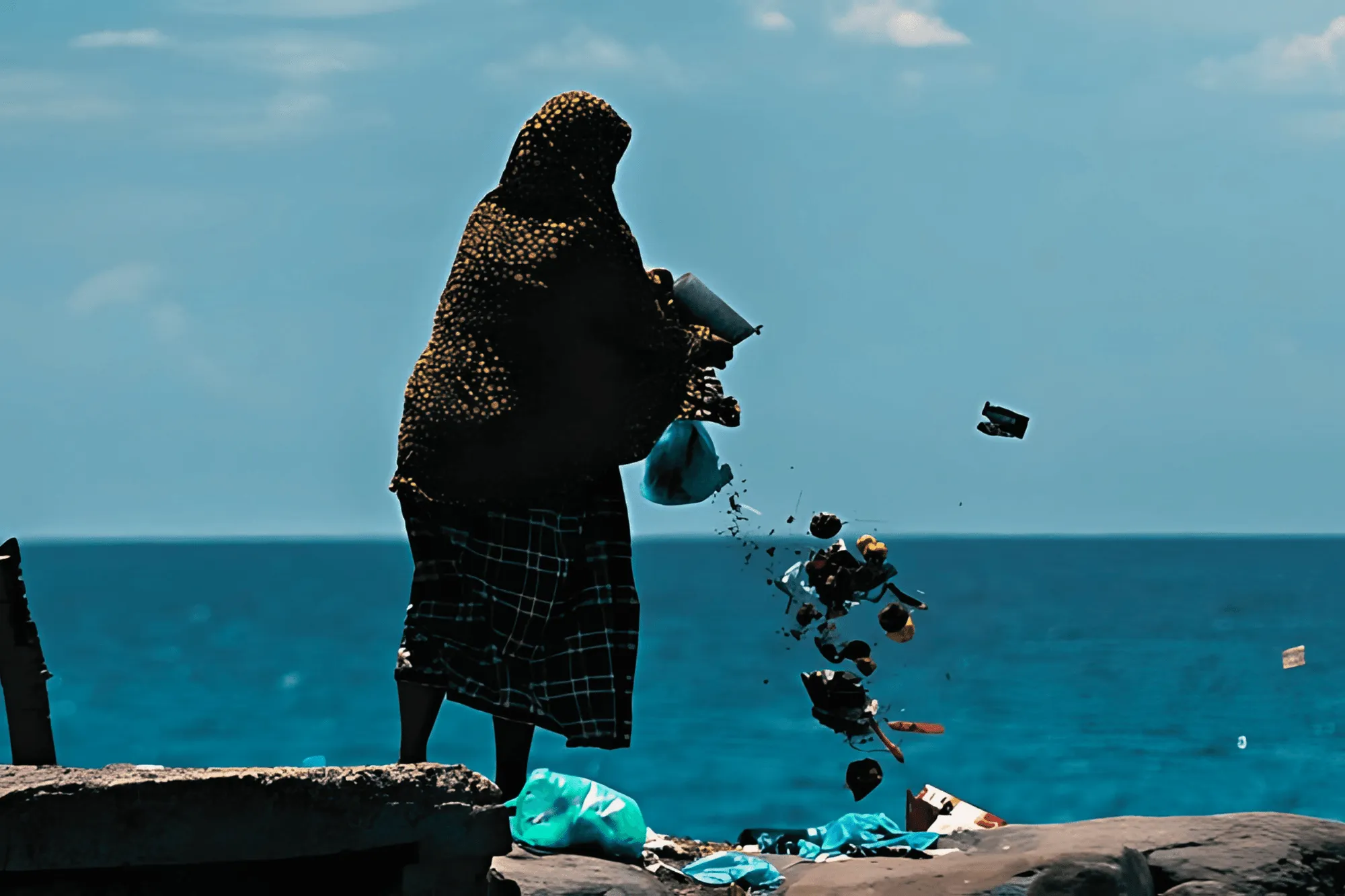 a woman throw garbage to the sea